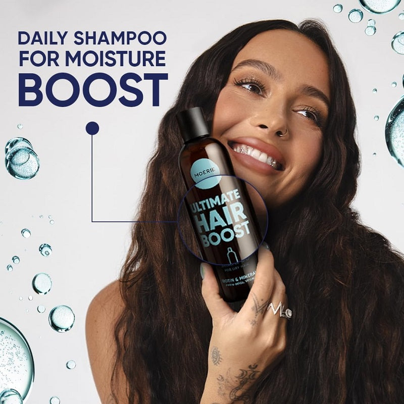 Moerie Ultimate Hair Boost moisturising shampoo bottle held by smiling woman