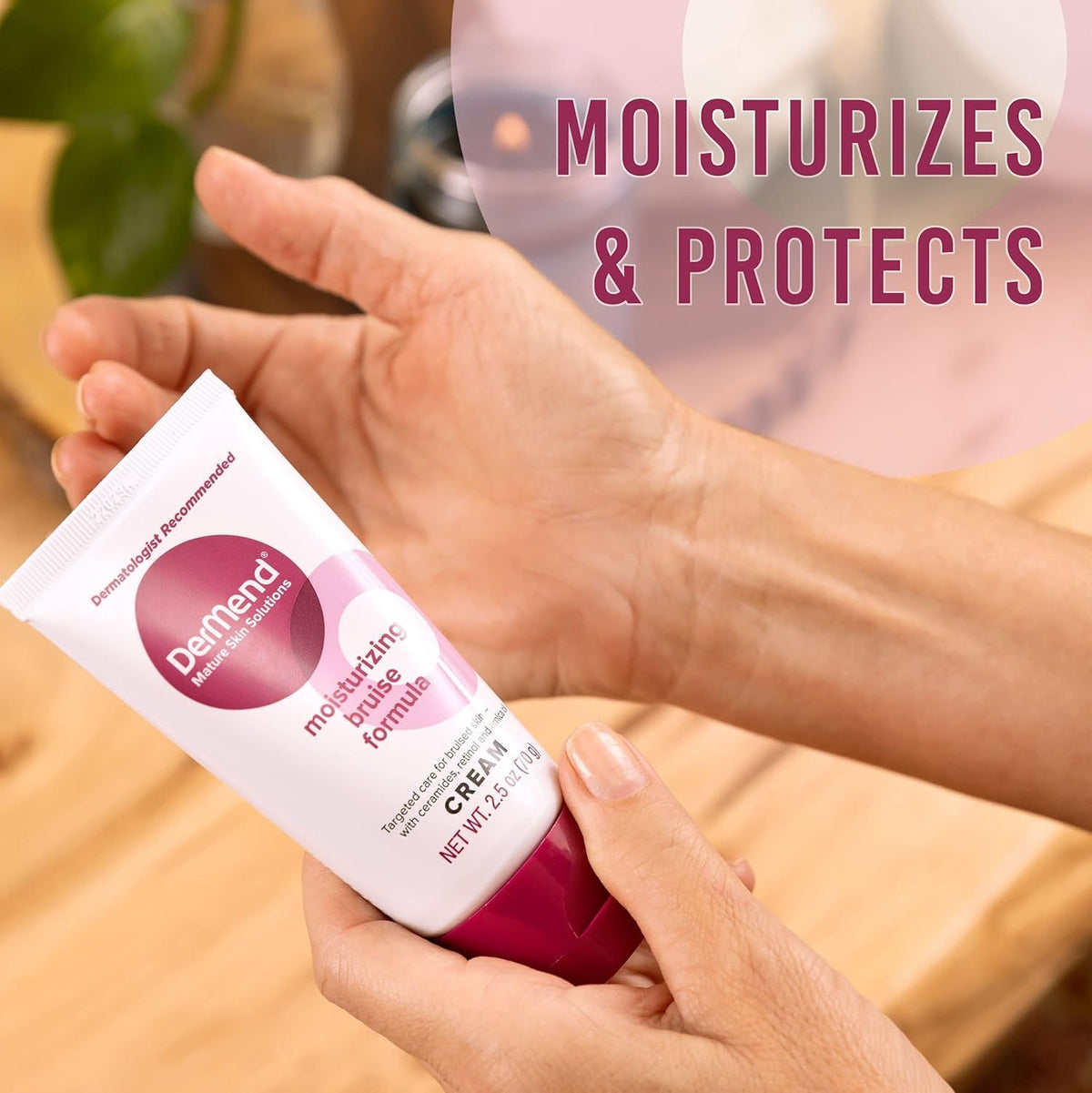 Moisturizing bruise formula cream tube held over palm, white with pink base