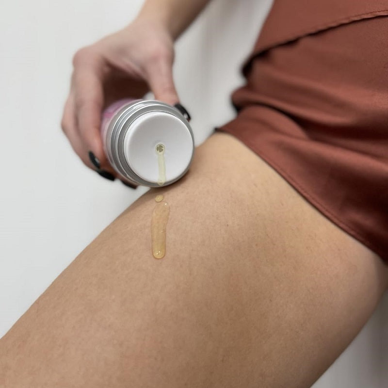 Intimate area brightening gel drop dispensed onto skin from open jar