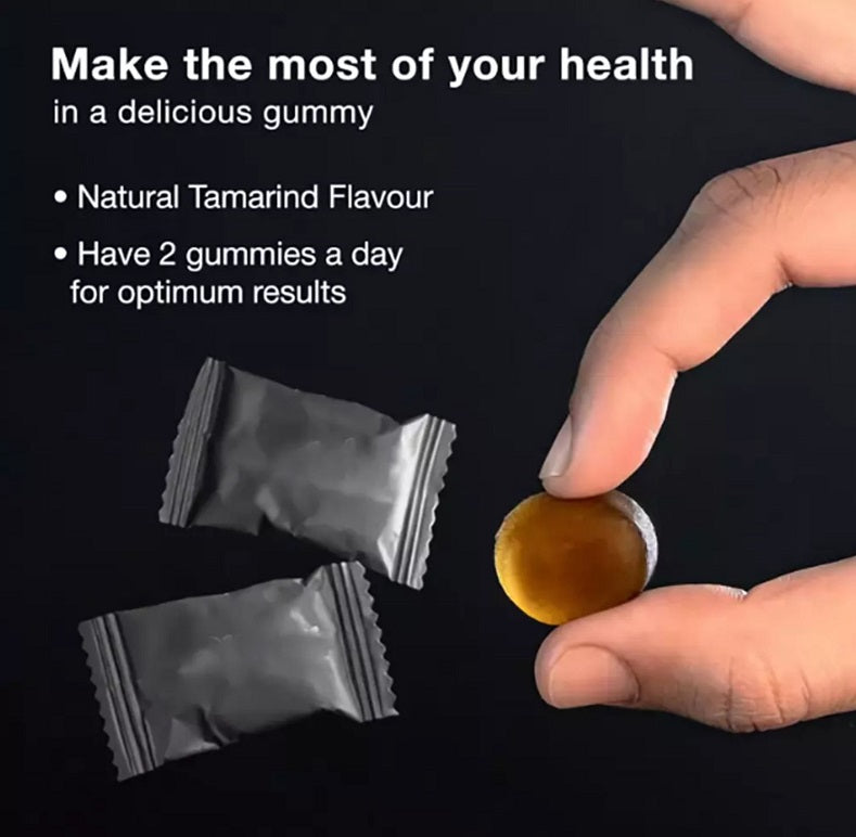 Shilajit gold gummies: single gummy held by hand with foil sachets