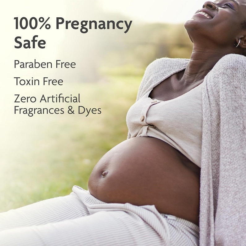 Pregnant belly with stretch mark prevention cream, woman wrapped in a towel