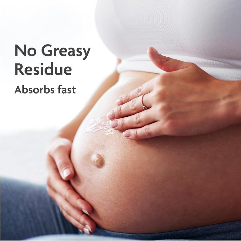 Hand massaging stretch mark prevention cream on pregnant belly, no-greasy residue