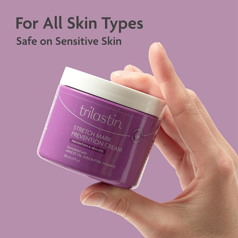trilastin stretch mark prevention cream jar held in hand, purple container with white lid
