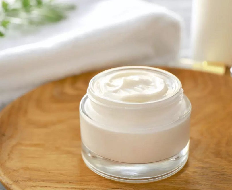 Enchanted Waters whipped tallow cream in clear glass jar, topped with white whipped cream