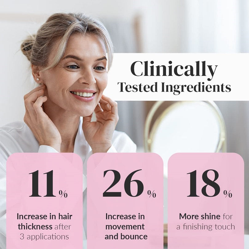 Woman smiling while holding a hair thickening treatment bottle