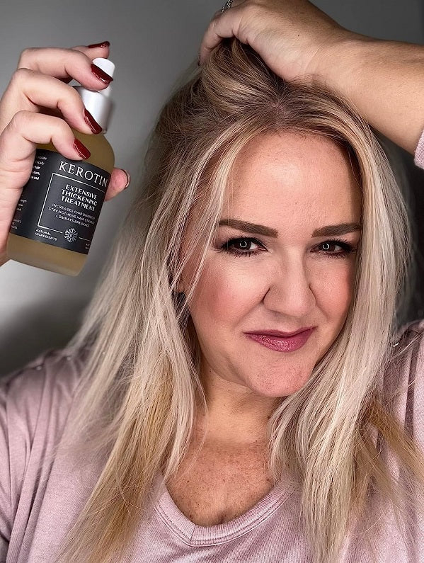 Woman holding a hair thickening treatment bottle near her blonde hair