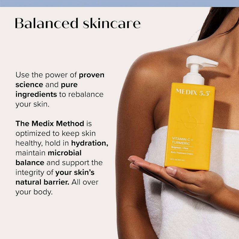 Body cream bottle with pump held in hand, yellow Vitamin C + Turmeric label