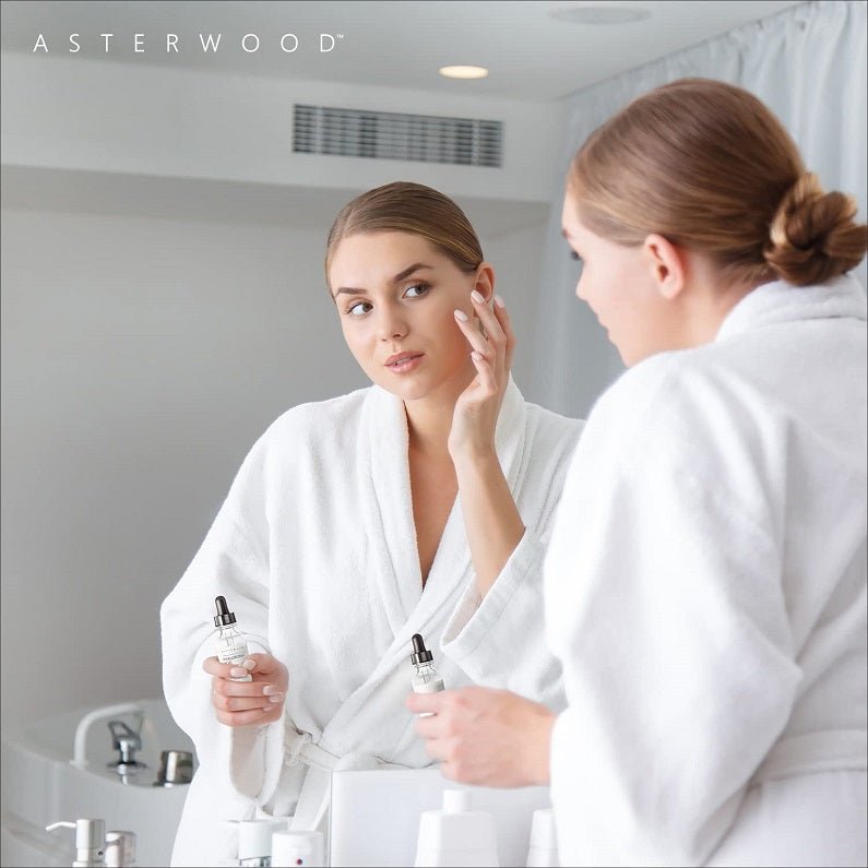 Hyaluronic acid anti-aging serum bottle held while applying skincare to face