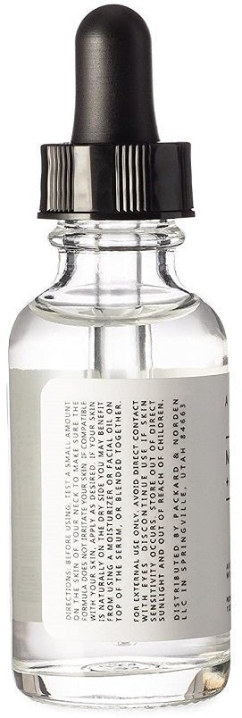 Anti-aging serum bottle with black dropper and clear liquid, back-label text close-up