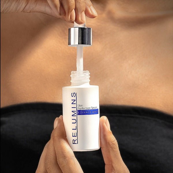 Skincare serum bottle with metal dropper cap, hands holding the dispenser